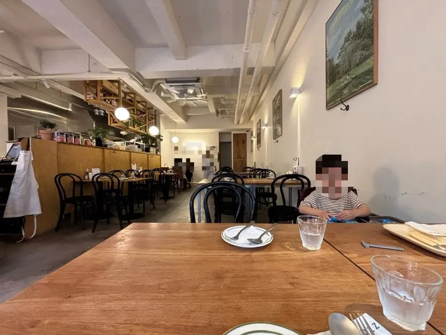원목 테이블과 조명, 액자가 있는 멜버즈 홀