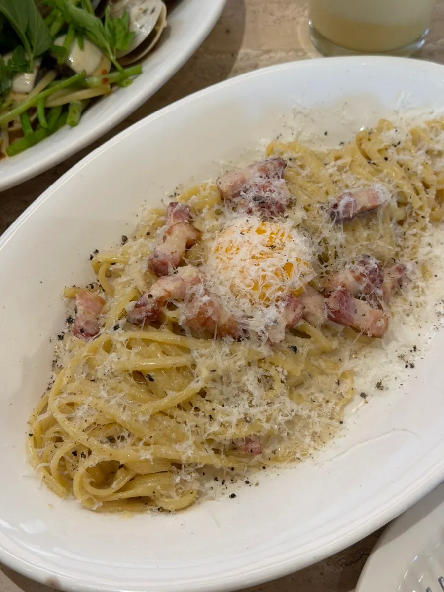 Classic carbonara pasta topped with an egg yolk