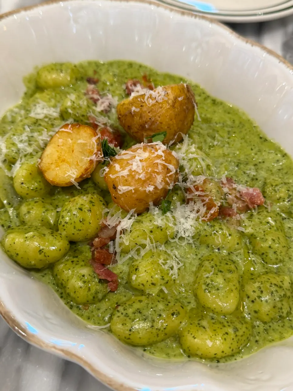 Gnocchi coated in green basil cream sauce