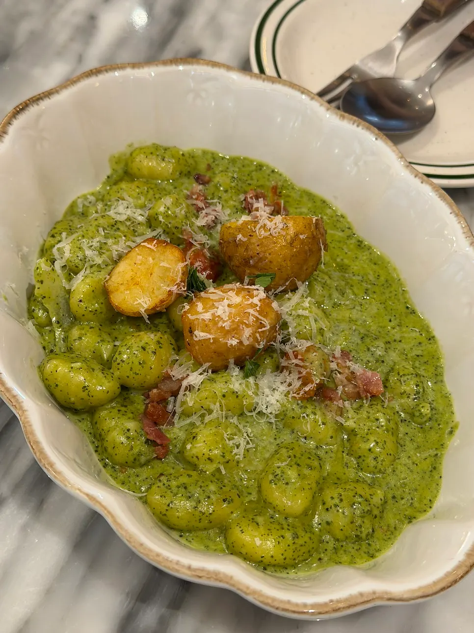 Close-up of basil cream gnocchi topped with grated cheese