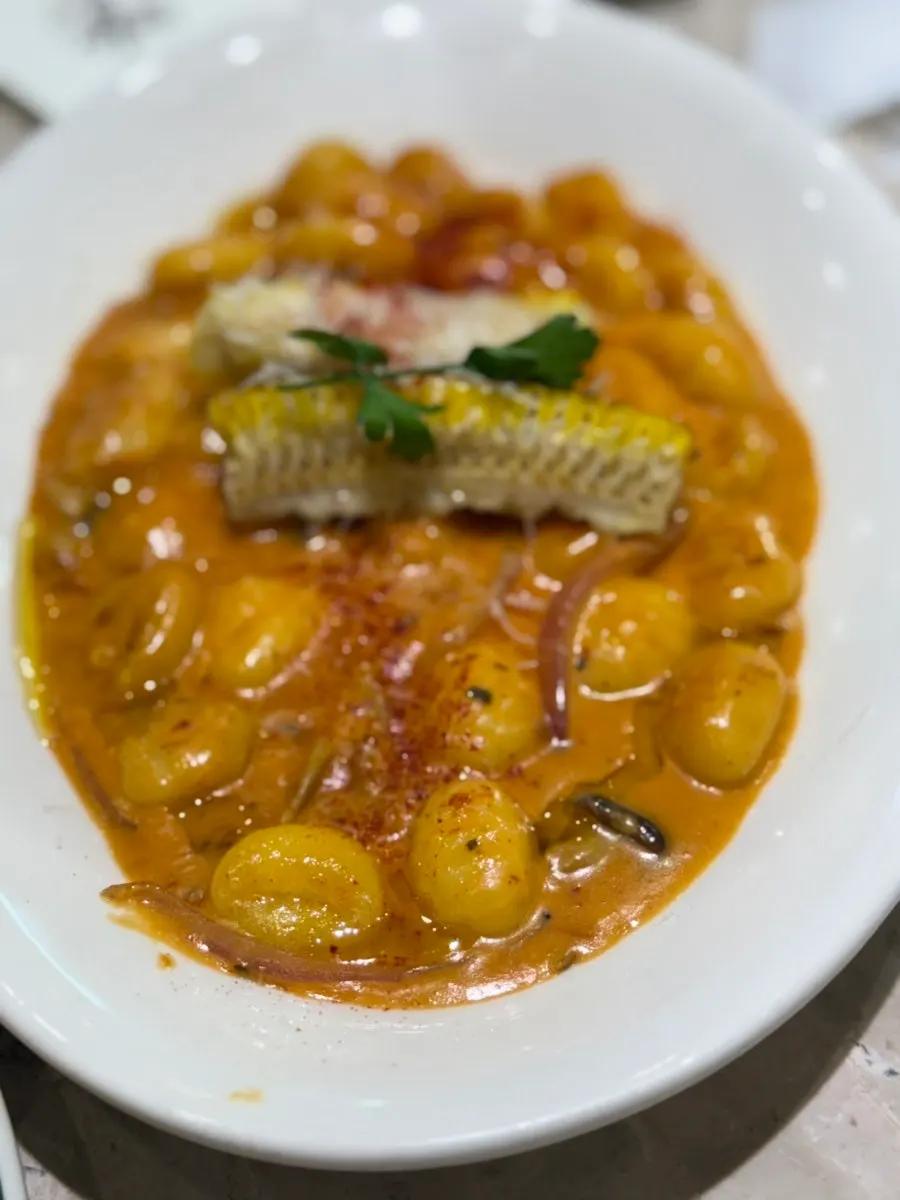 Mela's rose corn gnocchi on a ceramic plate