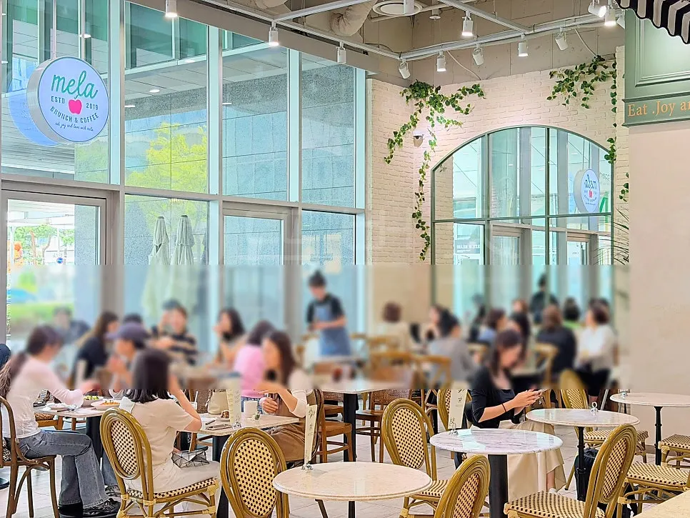 Interior of Mela, a high-ceilinged Times Square brunch café
