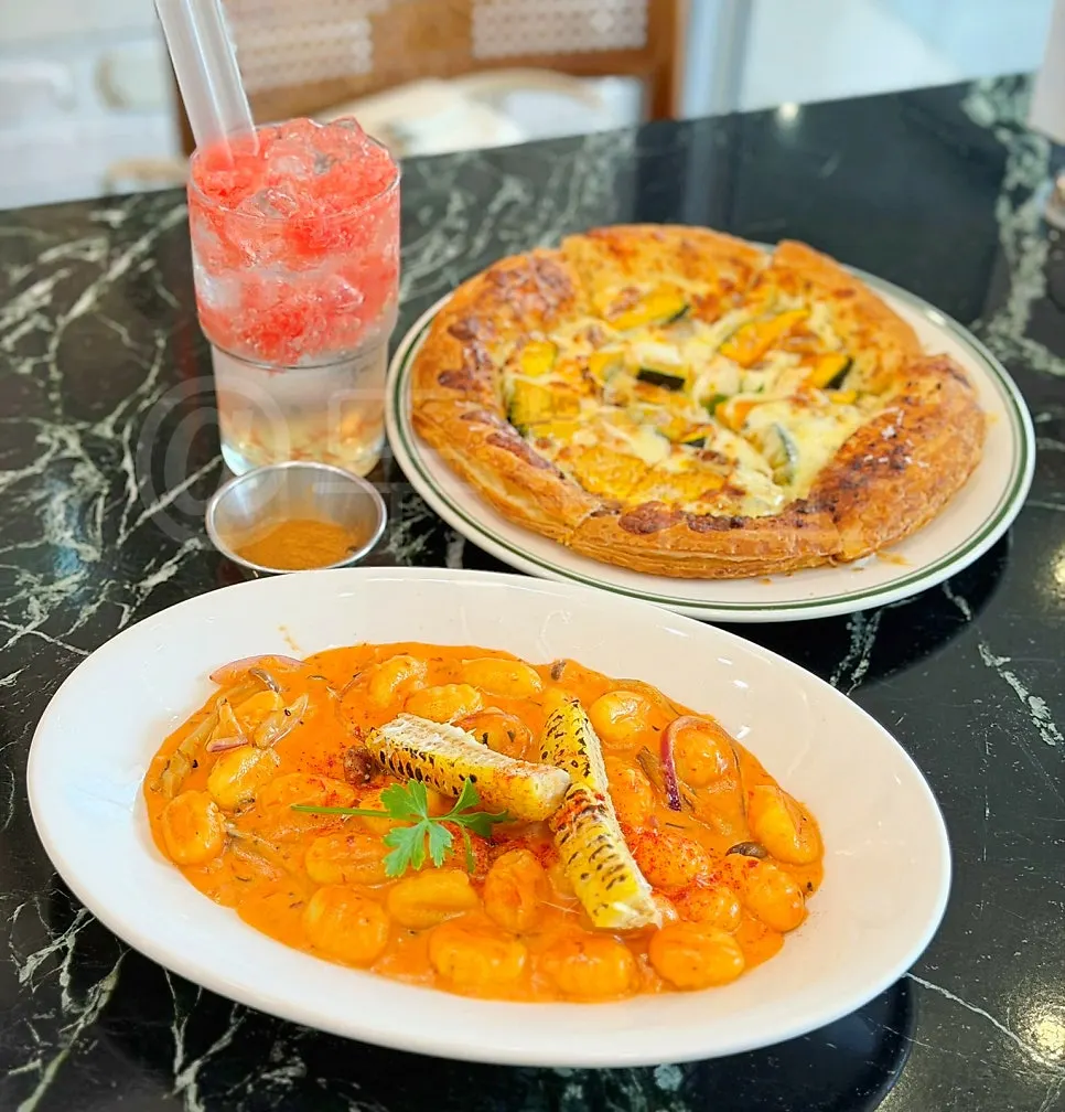 Table set with Mela's rose corn gnocchi and pizza