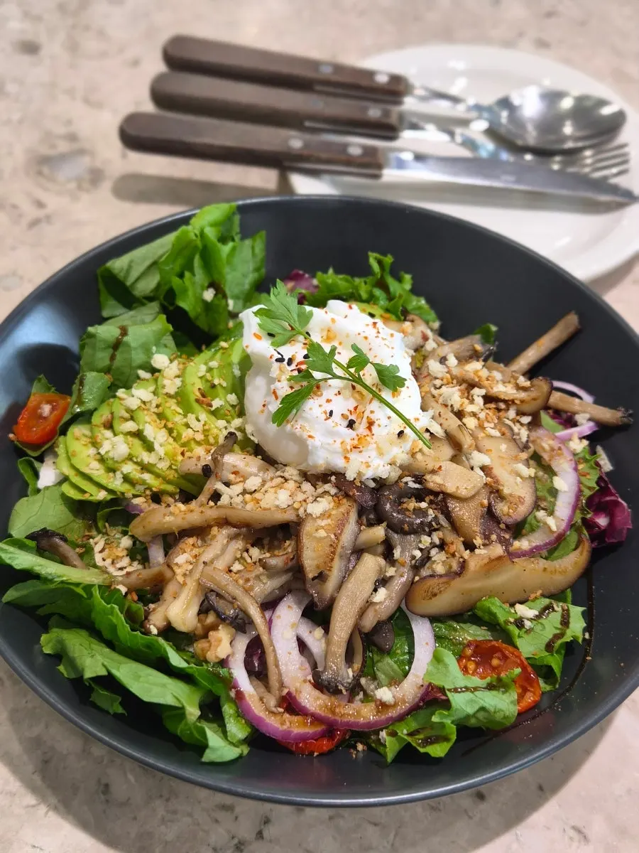 A bowl of mushroom avocado poached egg salad