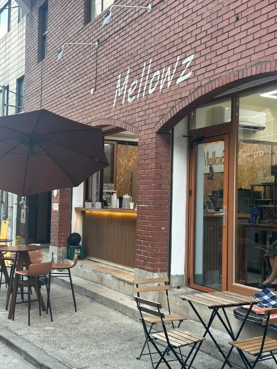 Exterior of Mellows with red-brick building and wood-tone terrace