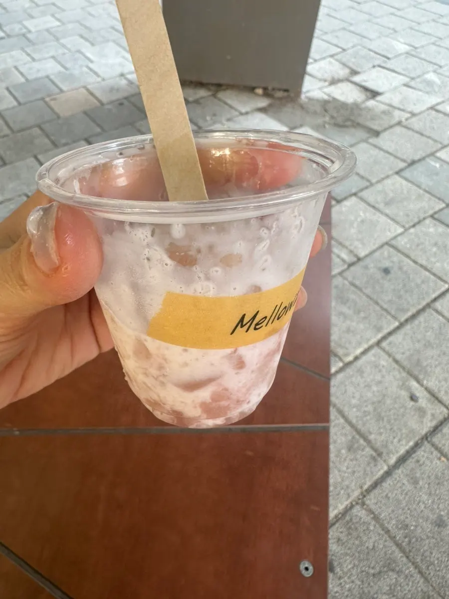 Close-up of a hand holding ice cream with fruit topping