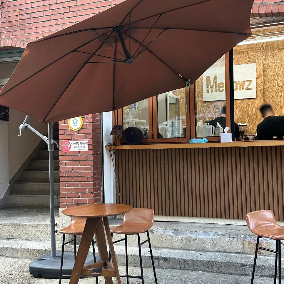 Outdoor seating with wood tables and chairs in front of the store