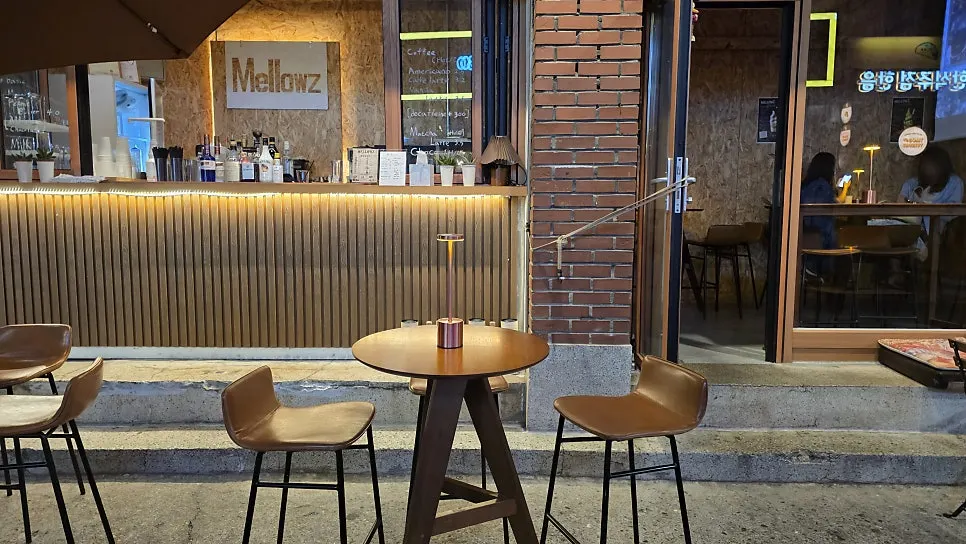 Outdoor tables in front of Mellows lit with soft lighting