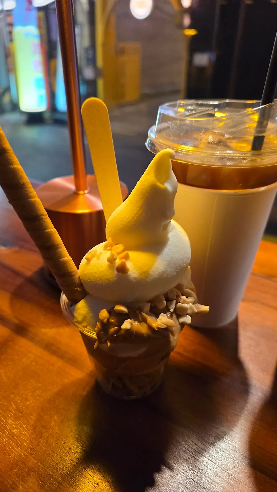 Peanut butter soft serve topped with nuts and a cookie stick