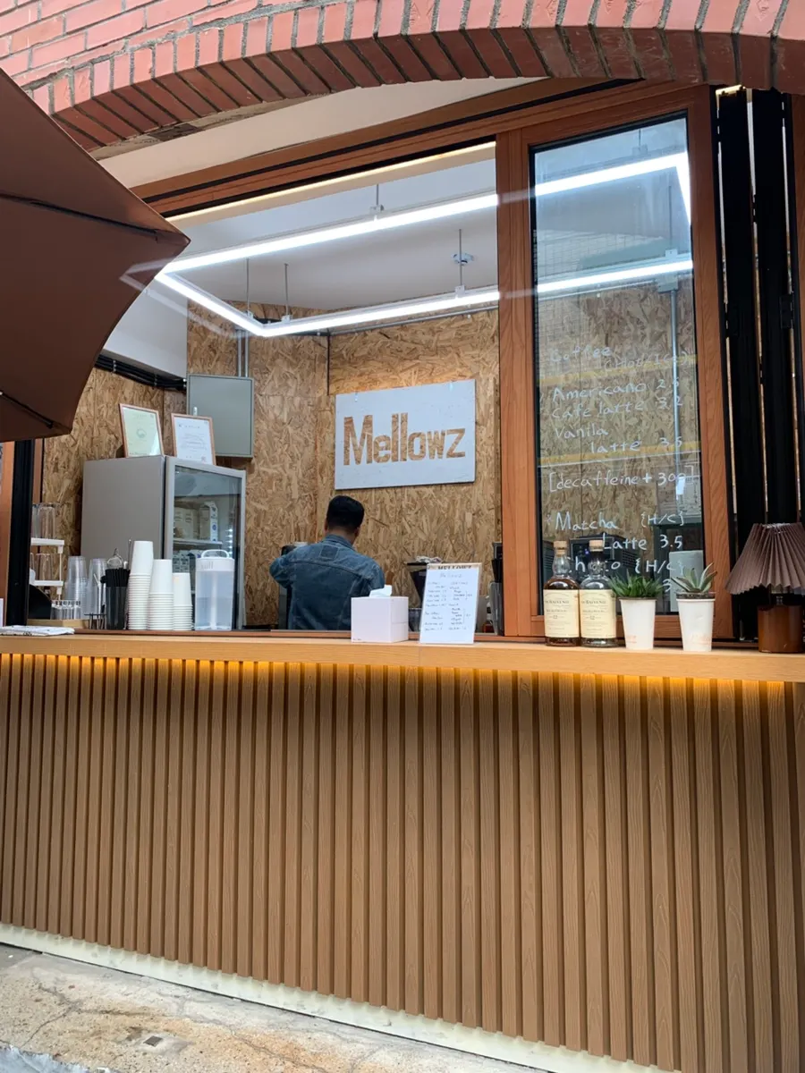 Outdoor tables and the store entrance in front of the Mellows building