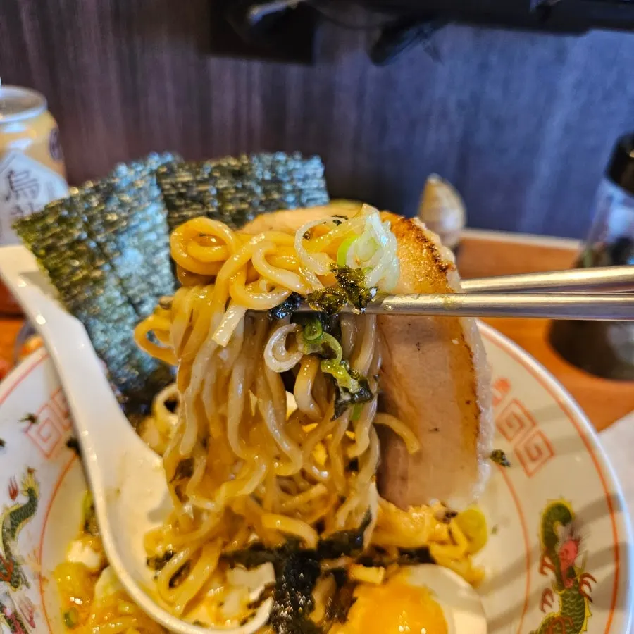 Picking up a big piece of chashu with the noodles