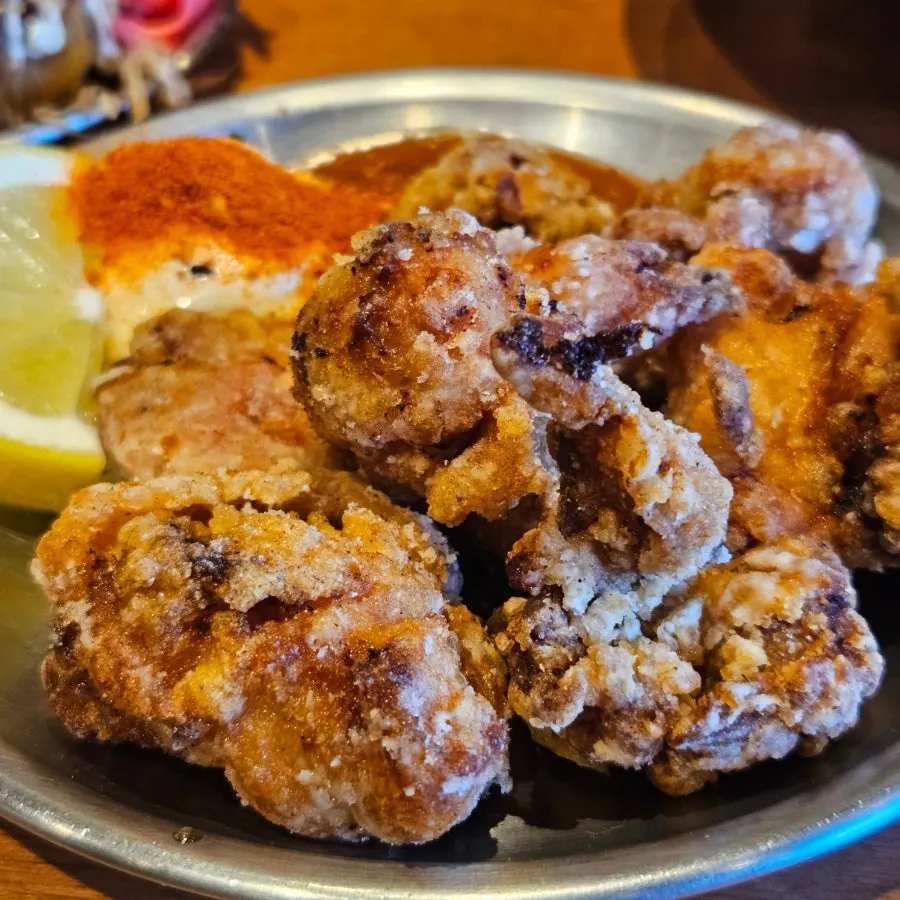 A piece of homemade chicken karaage with sauce