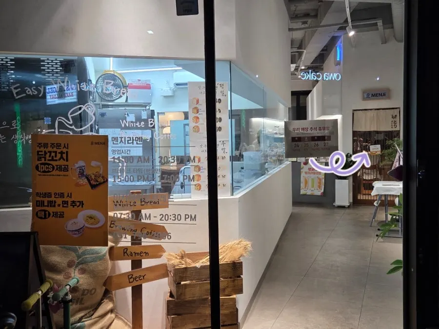 Exterior with the Menji Hanam Misa Branch sign next to the Easy White Bread sign
