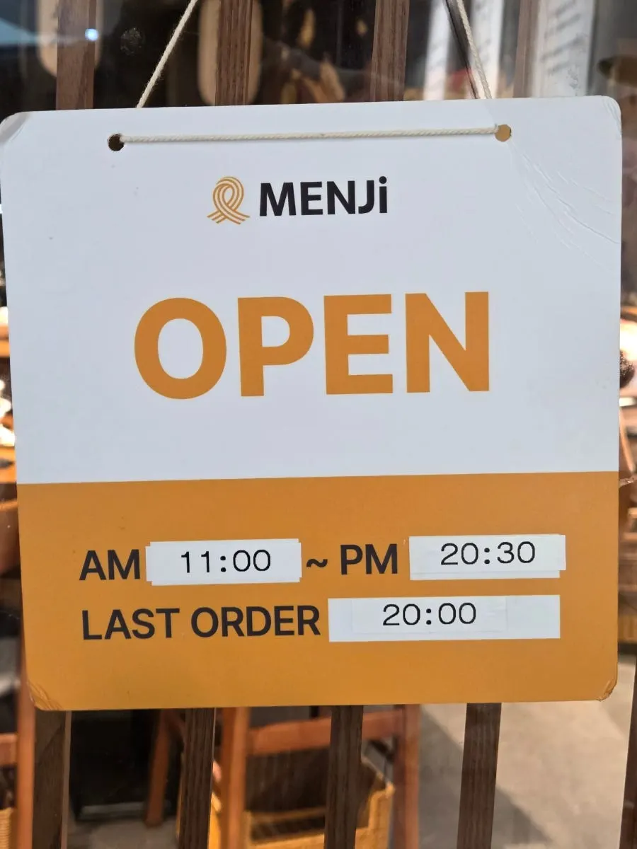 Photo marking the Menji entrance inside the bakery with an arrow