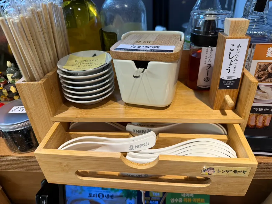 테이블 아래 수저통에 담긴 숟가락과 젓가락