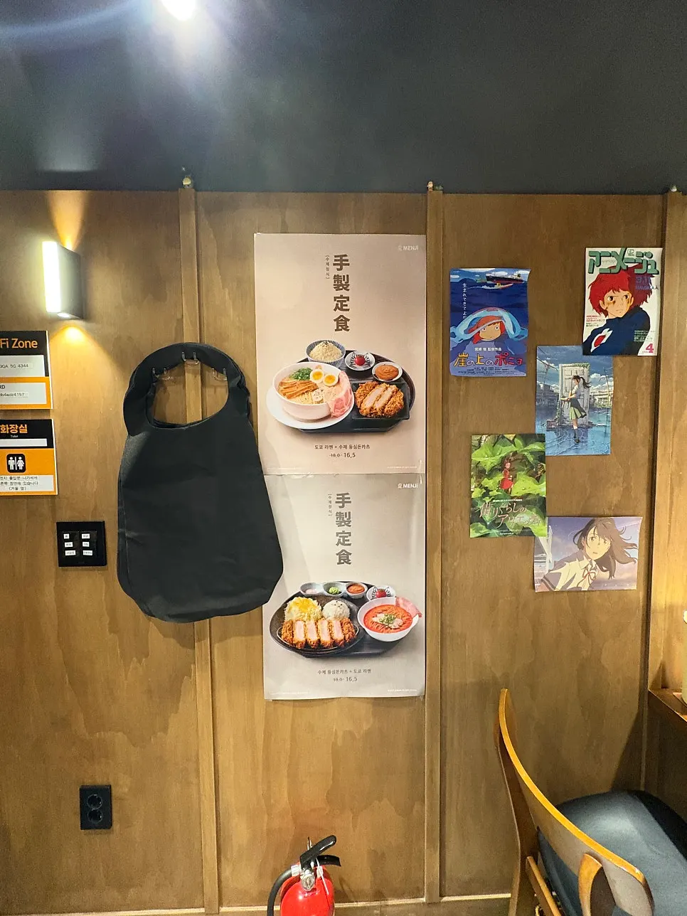 Wall decorated with anime posters and props
