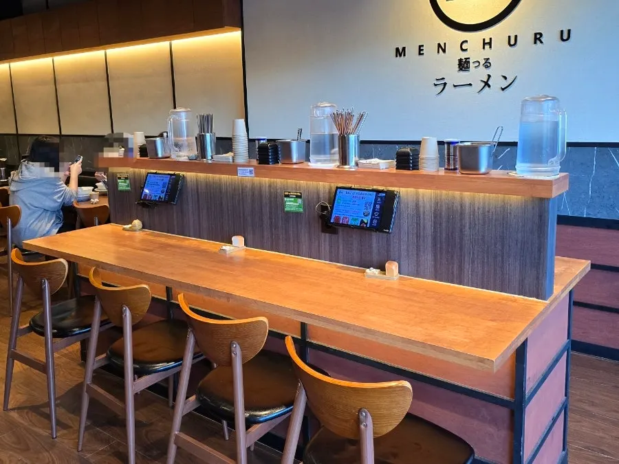 Bar seating and single-person tables in front of the kitchen at Mentsuru Children's Grand Park Branch