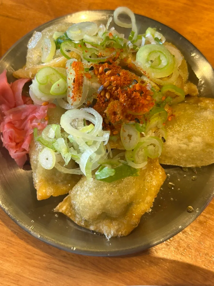 Fried gyoza topped with scallions and shichimi