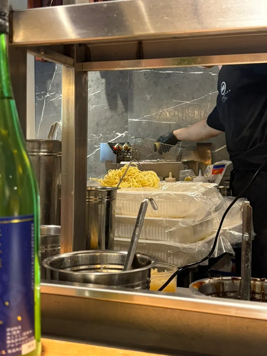Kitchen visible from the bar seats where noodles are boiled