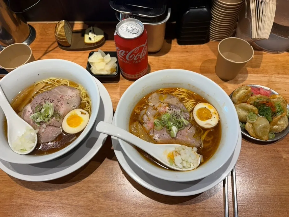 Table set with shoyu ramen, spicy shoyu ramen, and gyoza