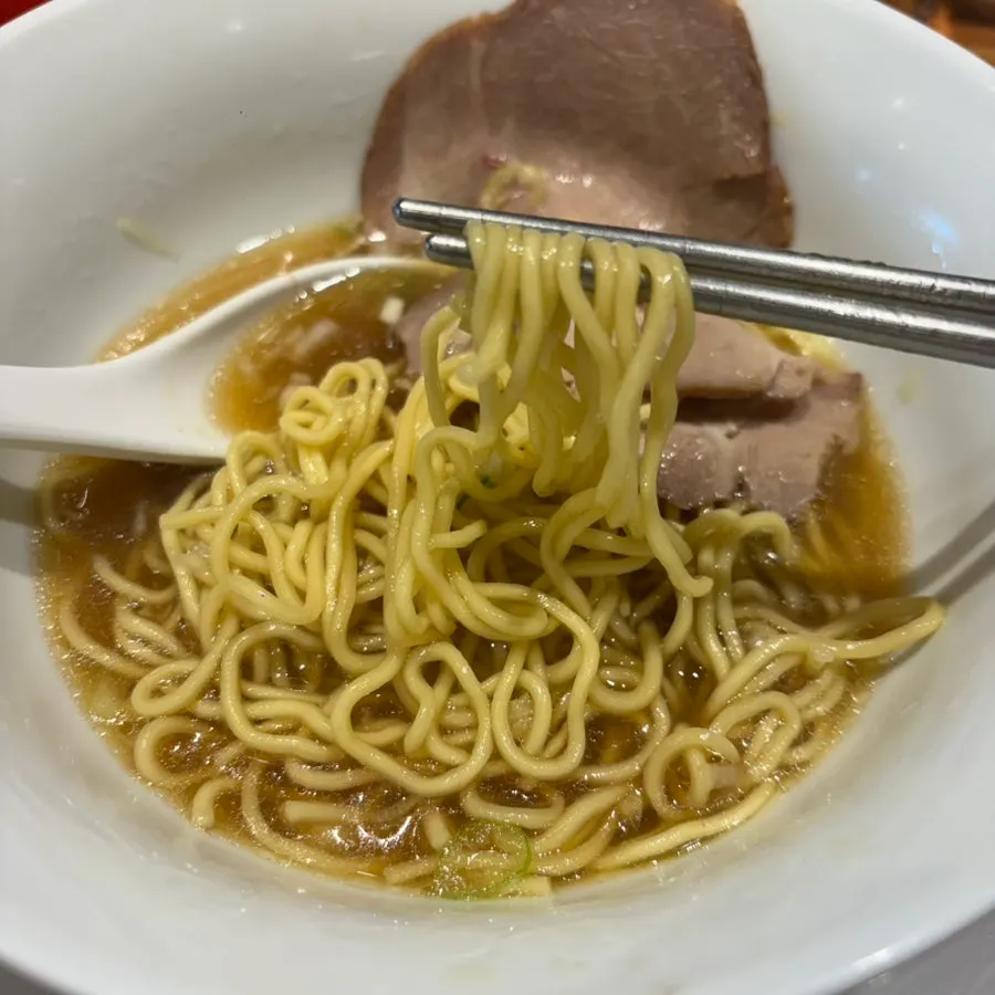 Chewy ramen noodles lifted with chopsticks