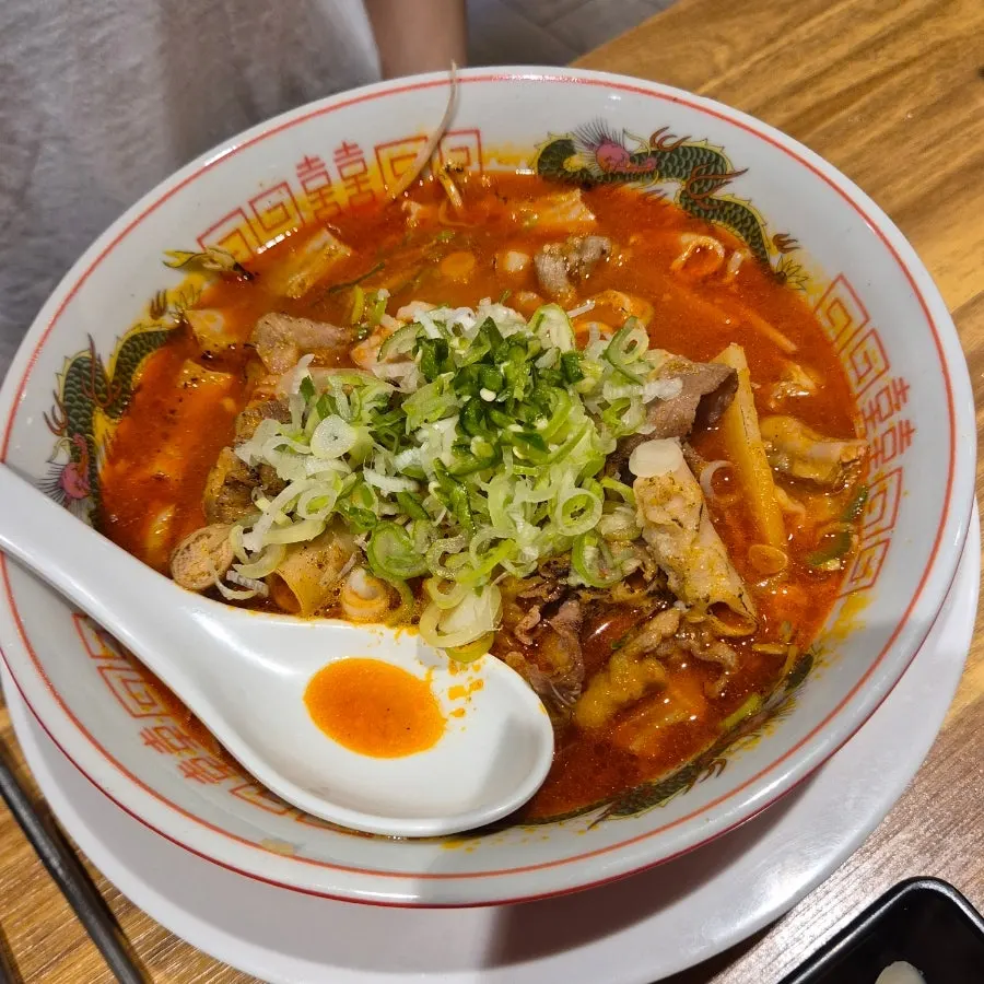 A bowl of motsu ramen topped with beef intestine and green onions