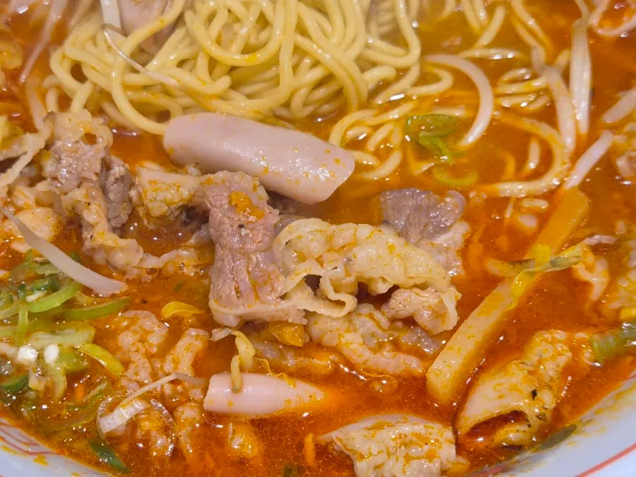 Motsu ramen showing red broth and bean sprouts