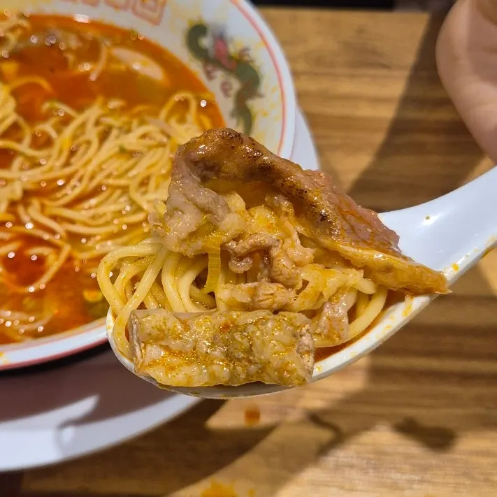 Noodles lifted up showing beef short rib belly in the motsu ramen