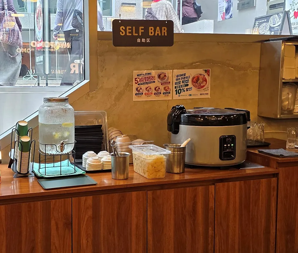 Self-serve bar with lemon water dispenser and cabbage pickles