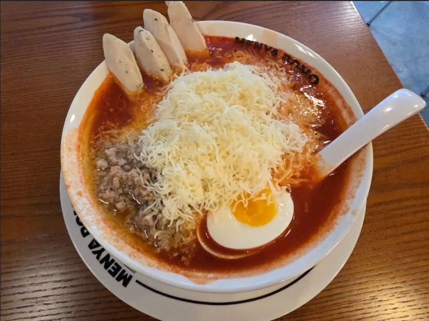 A bowl of cheese chicken tomato ramen