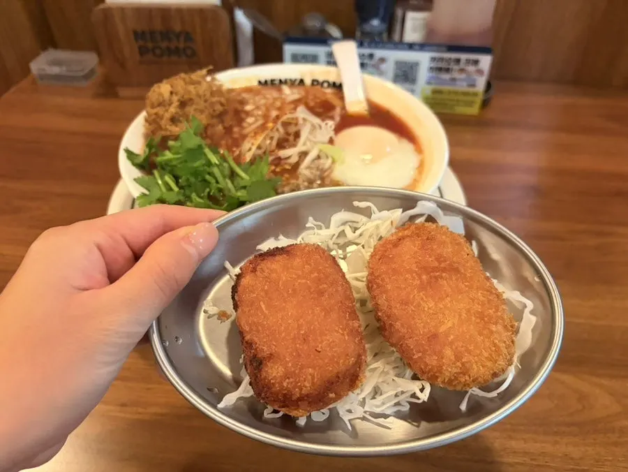 Two freshly fried potato croquettes