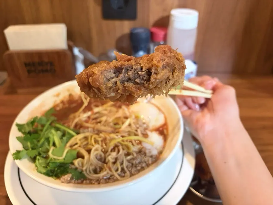 A piece of beef katsu dipped in tomato broth