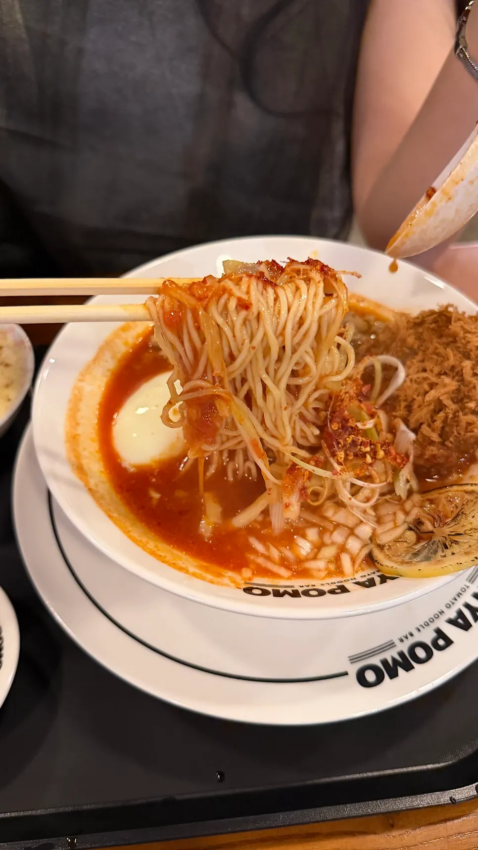 A bowl of tomato ramen photographed near the end of the meal