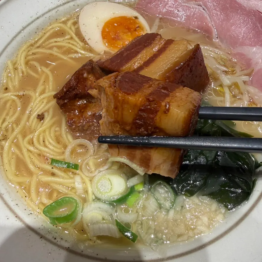 A piece of dongpo pork lifted with chopsticks