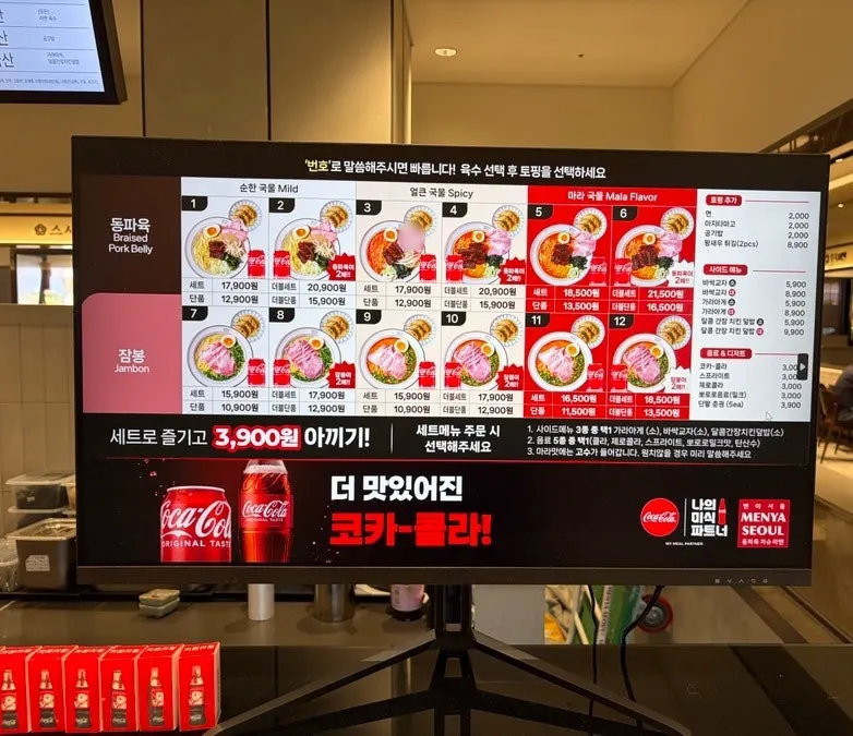 Bar-style seating wrapping around the Menya Seoul store