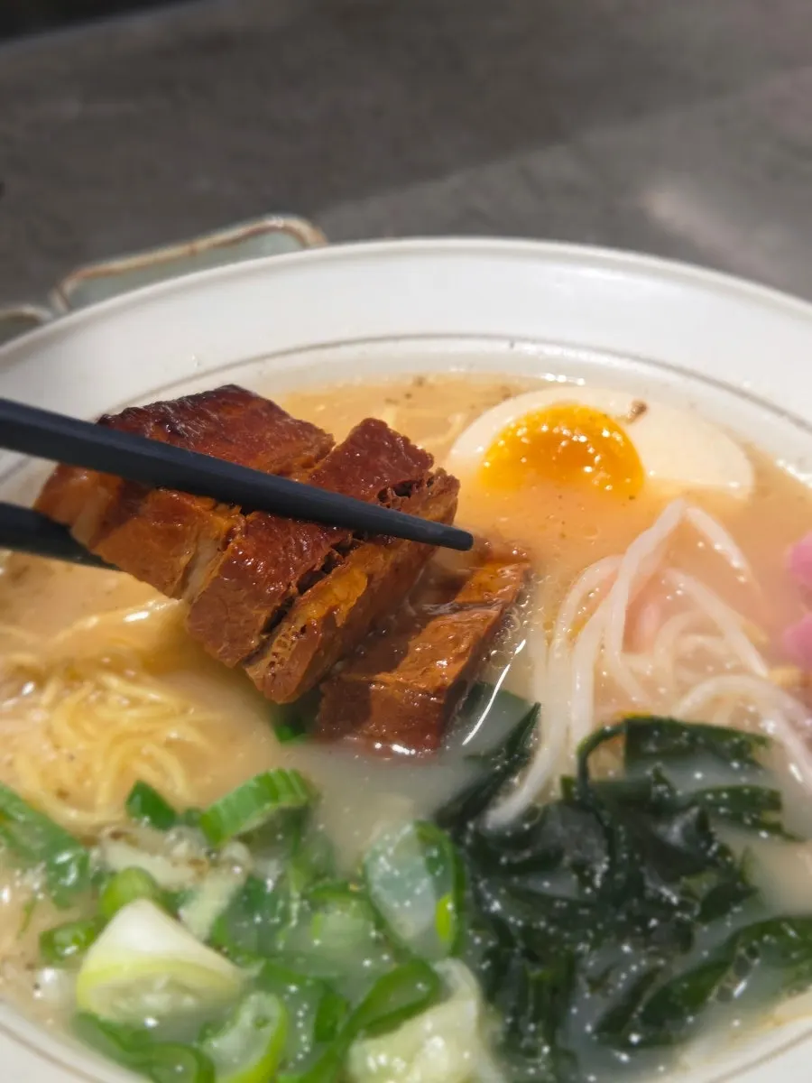 Close-up of ramen with soft-boiled egg, bean sprouts and seaweed toppings