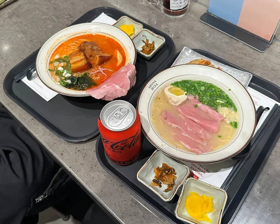 Two bowls of ramen served with kimchi and danmuji