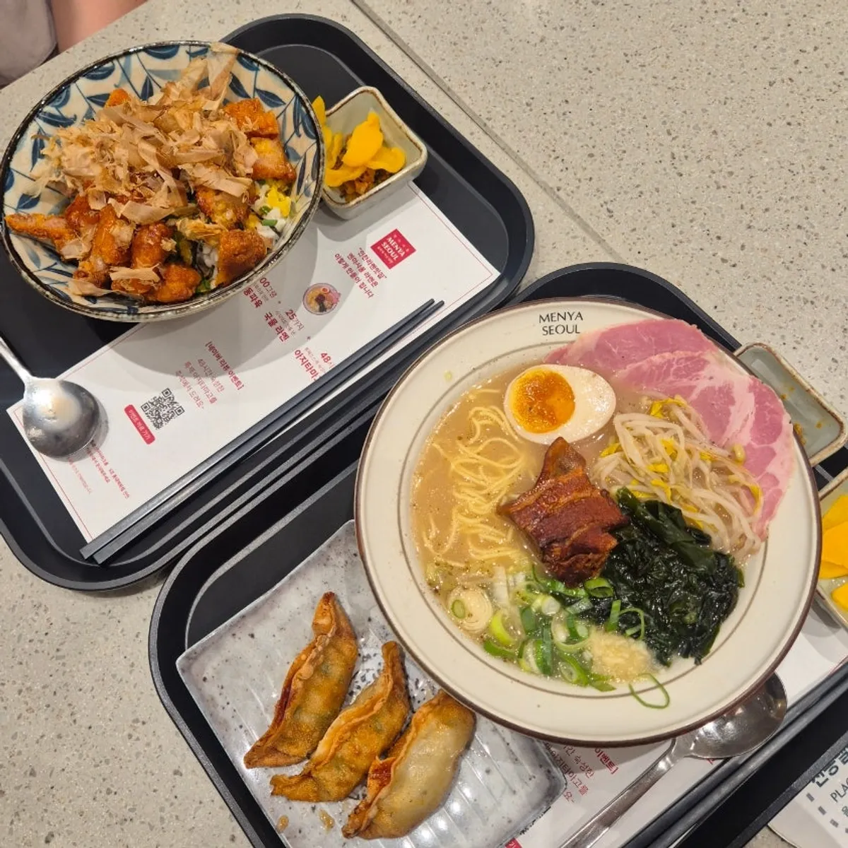 A table spread with dongpo pork char siu ramen, chicken rice bowl, and crispy gyoza