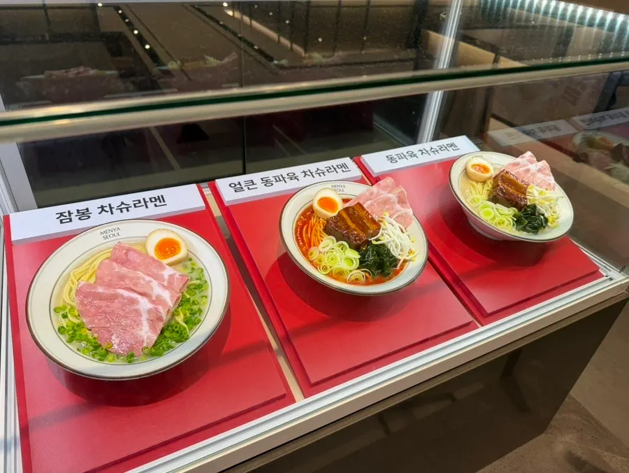 Menu board showing dongpo pork, jambon ramen and broth options