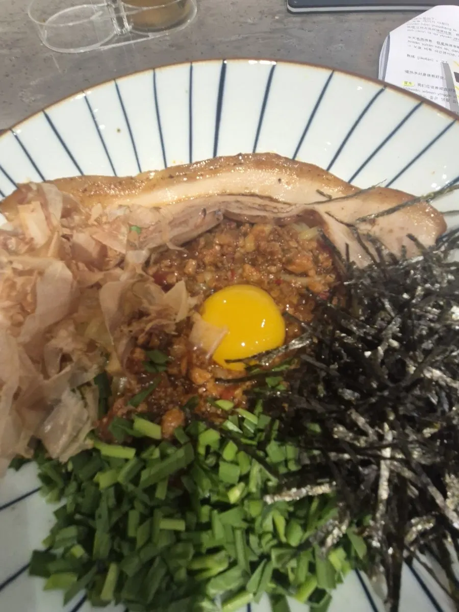 A bowl of pork belly mazesoba topped with pork belly at Menya Seoul