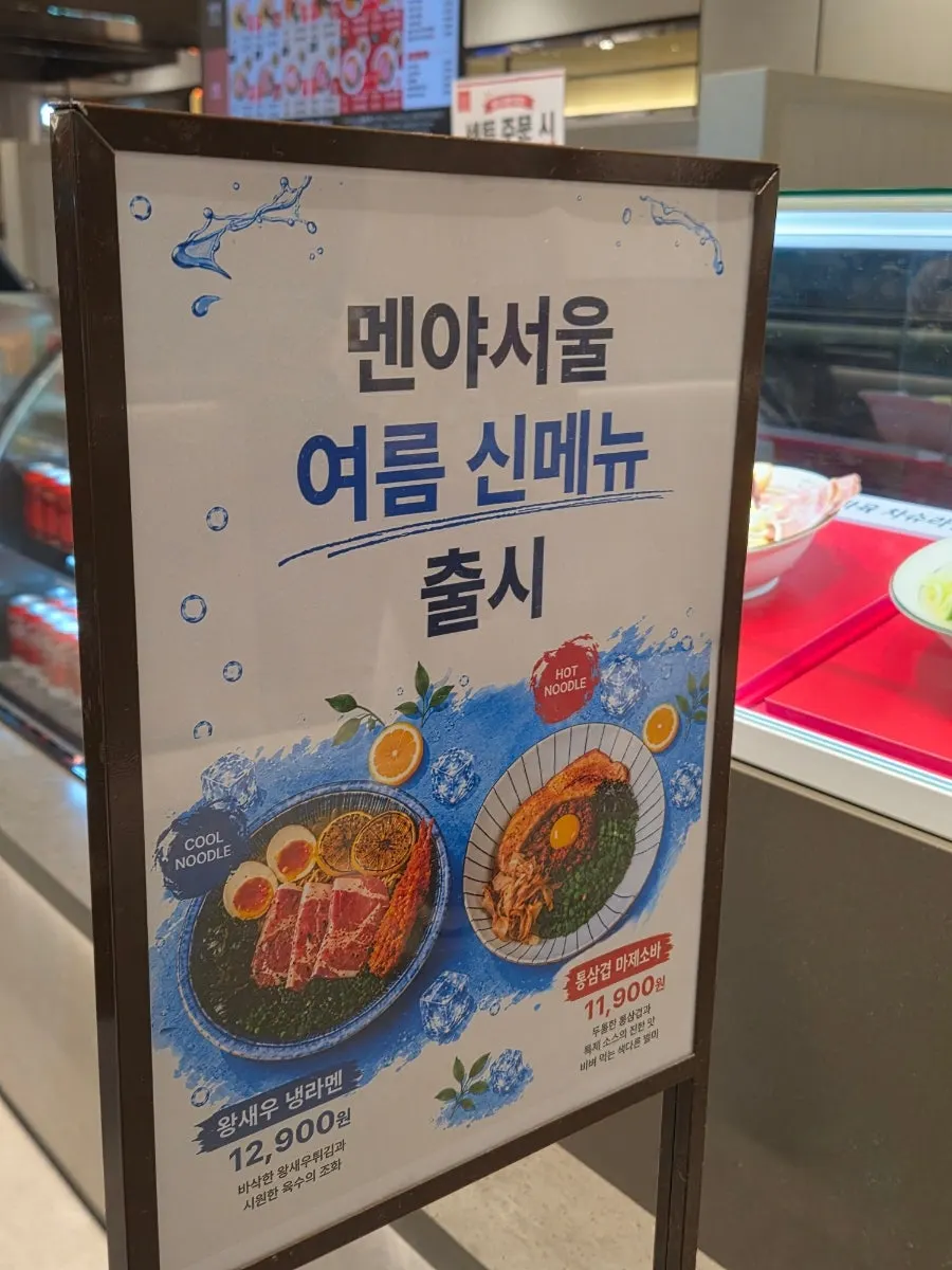 Menu board showing dongpo pork chashu ramen in spicy, clear, and mala versions
