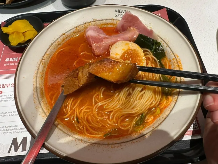 A bowl of spicy dongpo pork chashu ramen piled with toppings