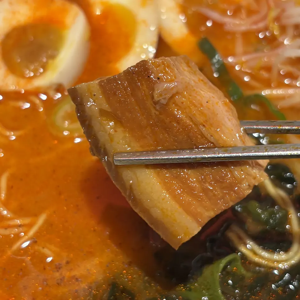A piece of dongpo pork picked up with chopsticks