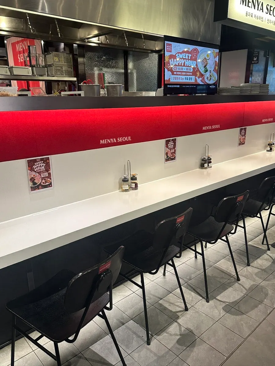 Bar seating in front of the Menya Seoul storefront