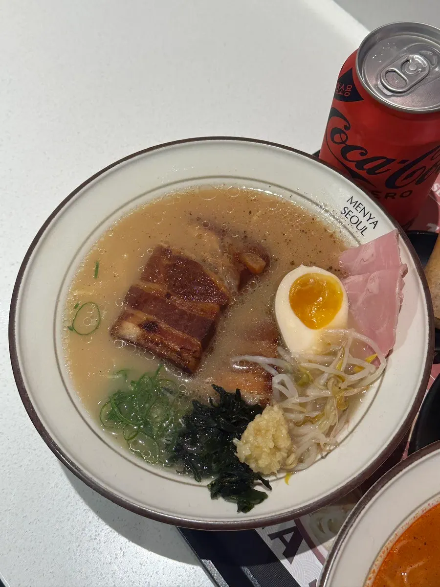 A bowl of ramen topped with noodles, chashu, and egg