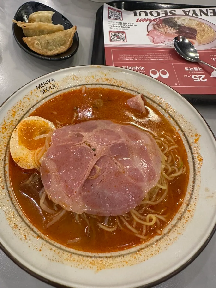 Thin ramen noodles lifted with chopsticks