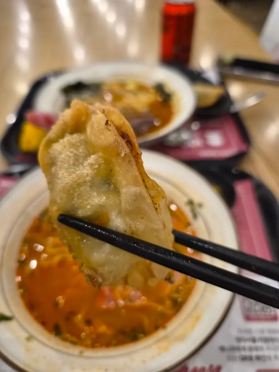 A gyoza cut in half showing the juicy filling