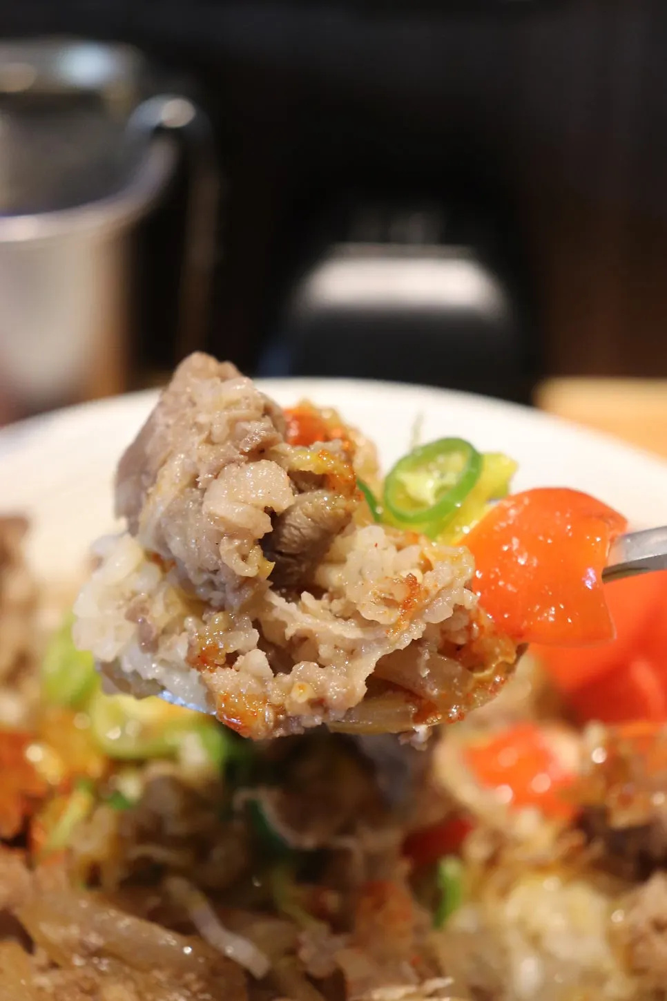 A spoonful of gyudon showing the rice-to-beef ratio