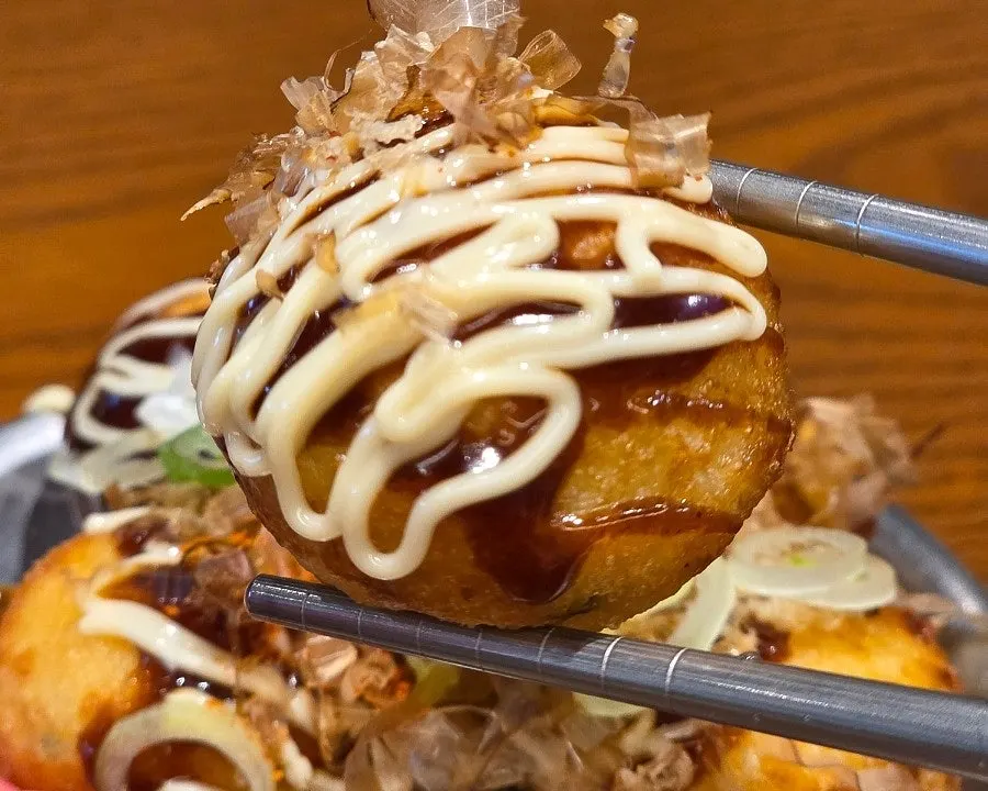 Takoyaki topped with mayo sauce and bonito flakes