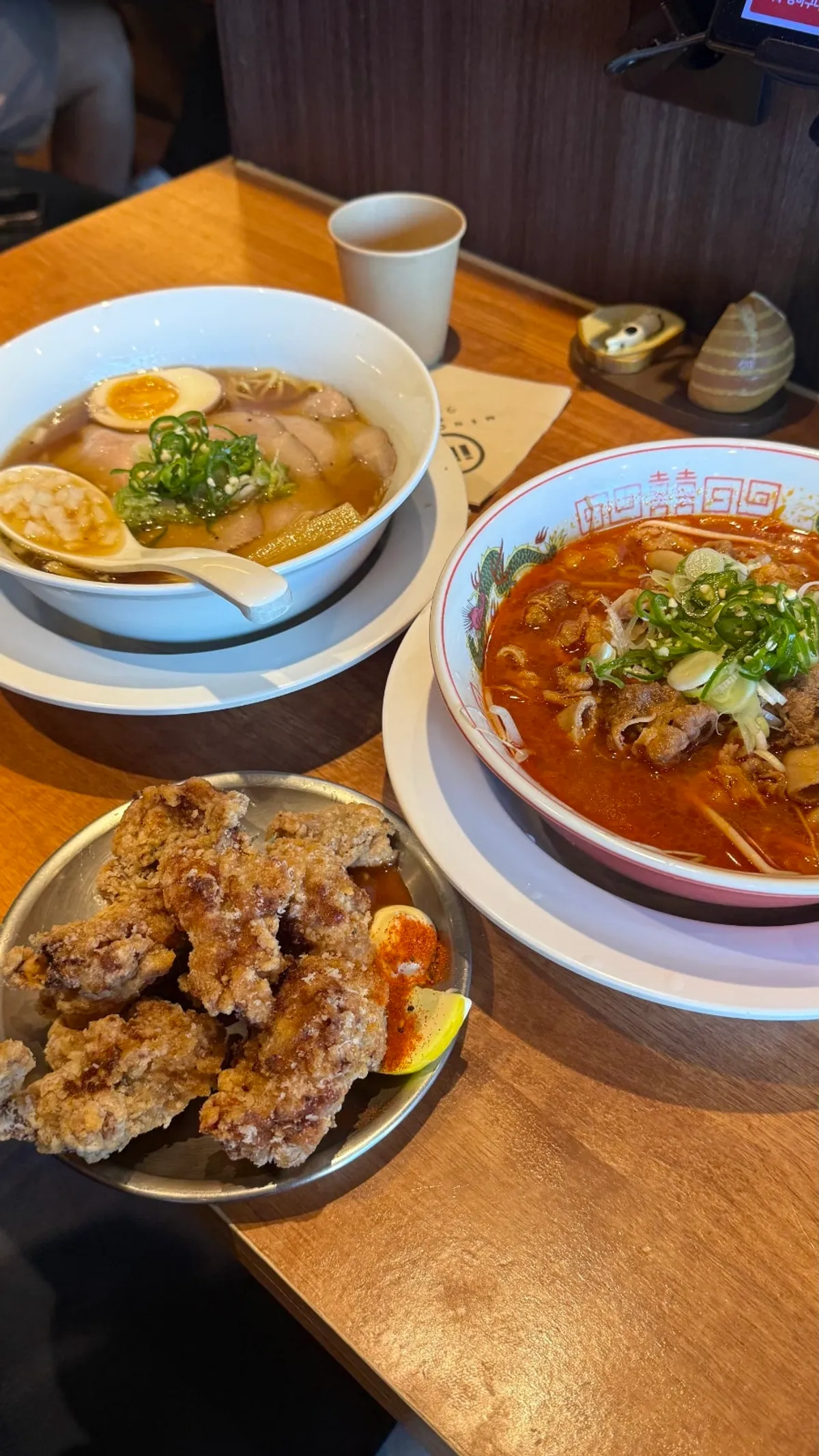Table spread of shoyu ramen, motsu ramen and karaage